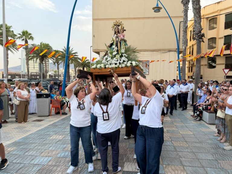 Grupo de personas llevando la imagen de la Virgen del Carmen en procesión.
