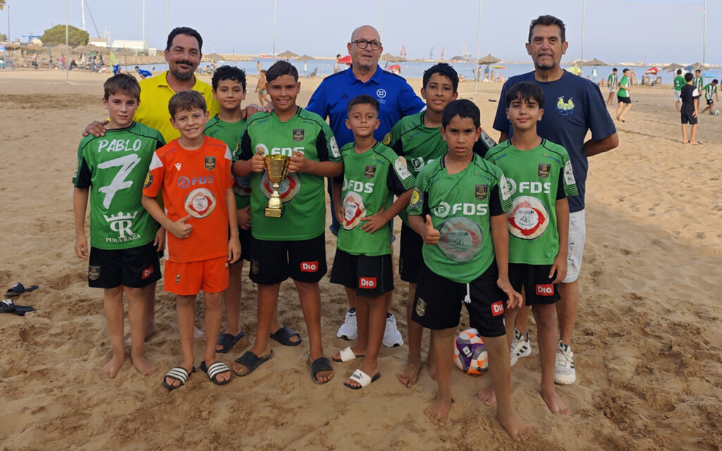 Equipo Milenium F.S. posando con trofeo en la playa
