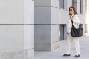 Cristina Narbona caminando con un bolso negro en un entorno urbano.