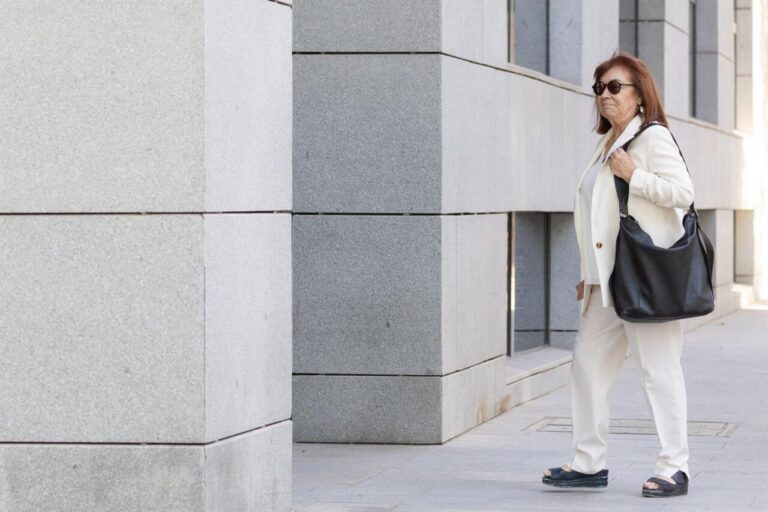 Cristina Narbona caminando con un bolso negro en un entorno urbano.