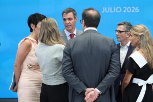 Pedro Sánchez hablando con sus vicepresidentes en un evento político