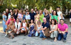 Grupo de personas en el Orgullo de Madrid con banderas y abanicos.