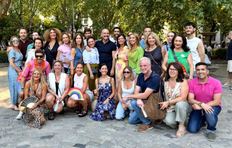Grupo de personas en el Orgullo de Madrid con banderas y abanicos.