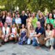 Grupo de personas en el Orgullo de Madrid con banderas y abanicos.