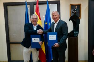 Dos hombres estrechando manos tras firmar un convenio en Melilla