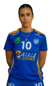 Person wearing a blue sports jersey with the number 10, standing with hands behind back; team logos and 'CIUDAD DEL DEPORTE' text are visible on the shirt.