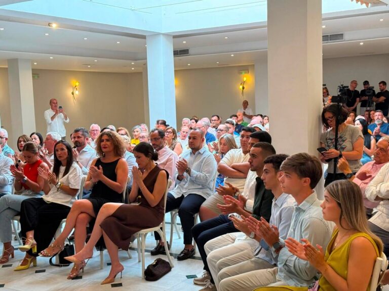 Sofía Acedo y Miguel Tellado en un evento en Melilla con audiencia aplaudiendo.