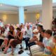 Sofía Acedo y Miguel Tellado en un evento en Melilla con audiencia aplaudiendo.