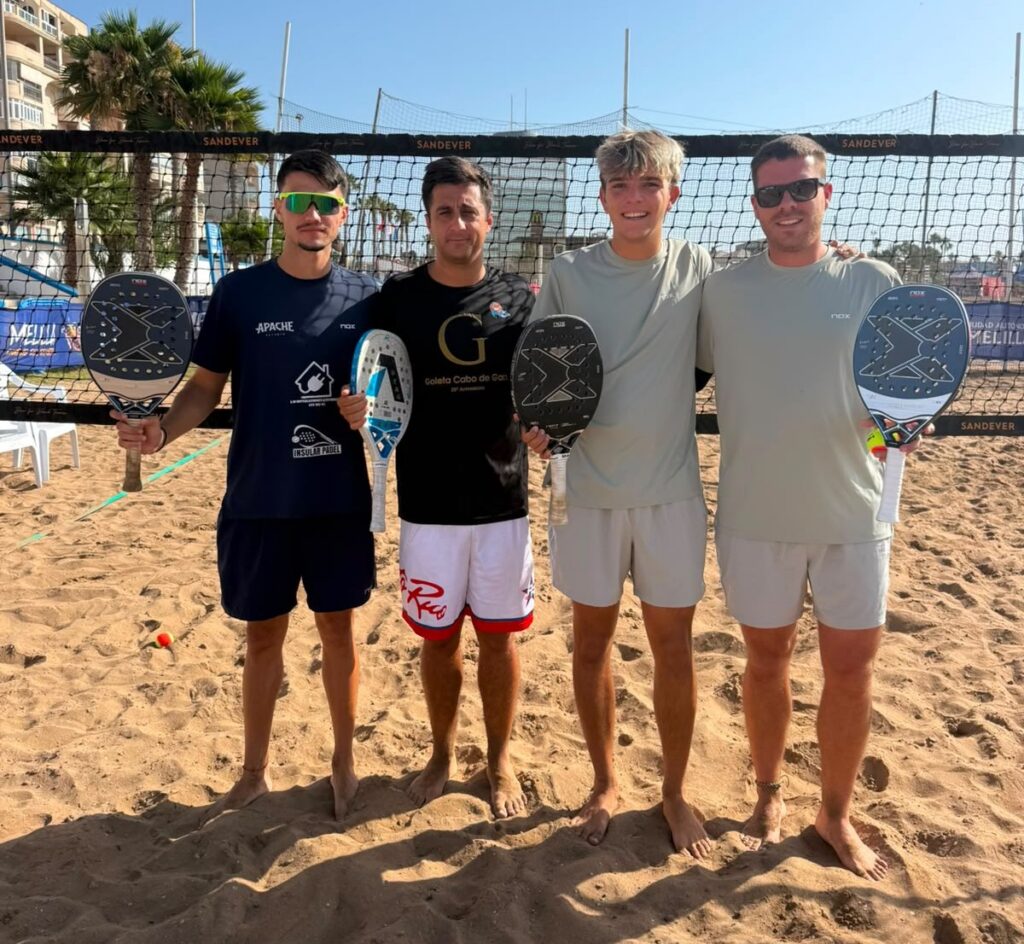 Jugadores de tenis playa sosteniendo palas en la arena