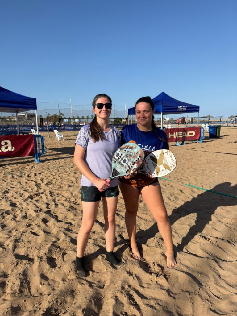María Martínez y Nicolás Volpe posando en la Playa de San Lorenzo con palas de tenis playa