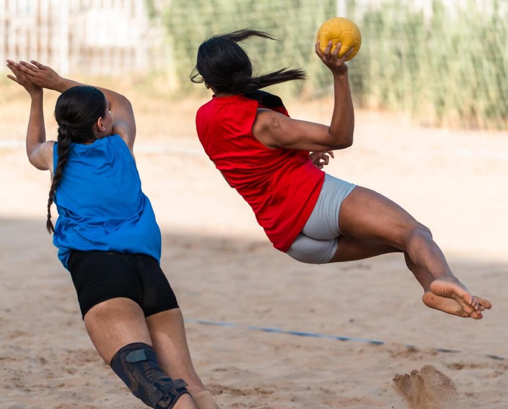 Jugadoras de balonmano playa compitiendo en la arena