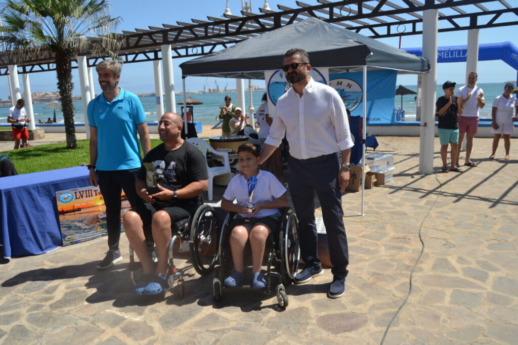 Premiación de la LVIII Travesía a Nado Ciudad de Melilla con participantes en sillas de ruedas.