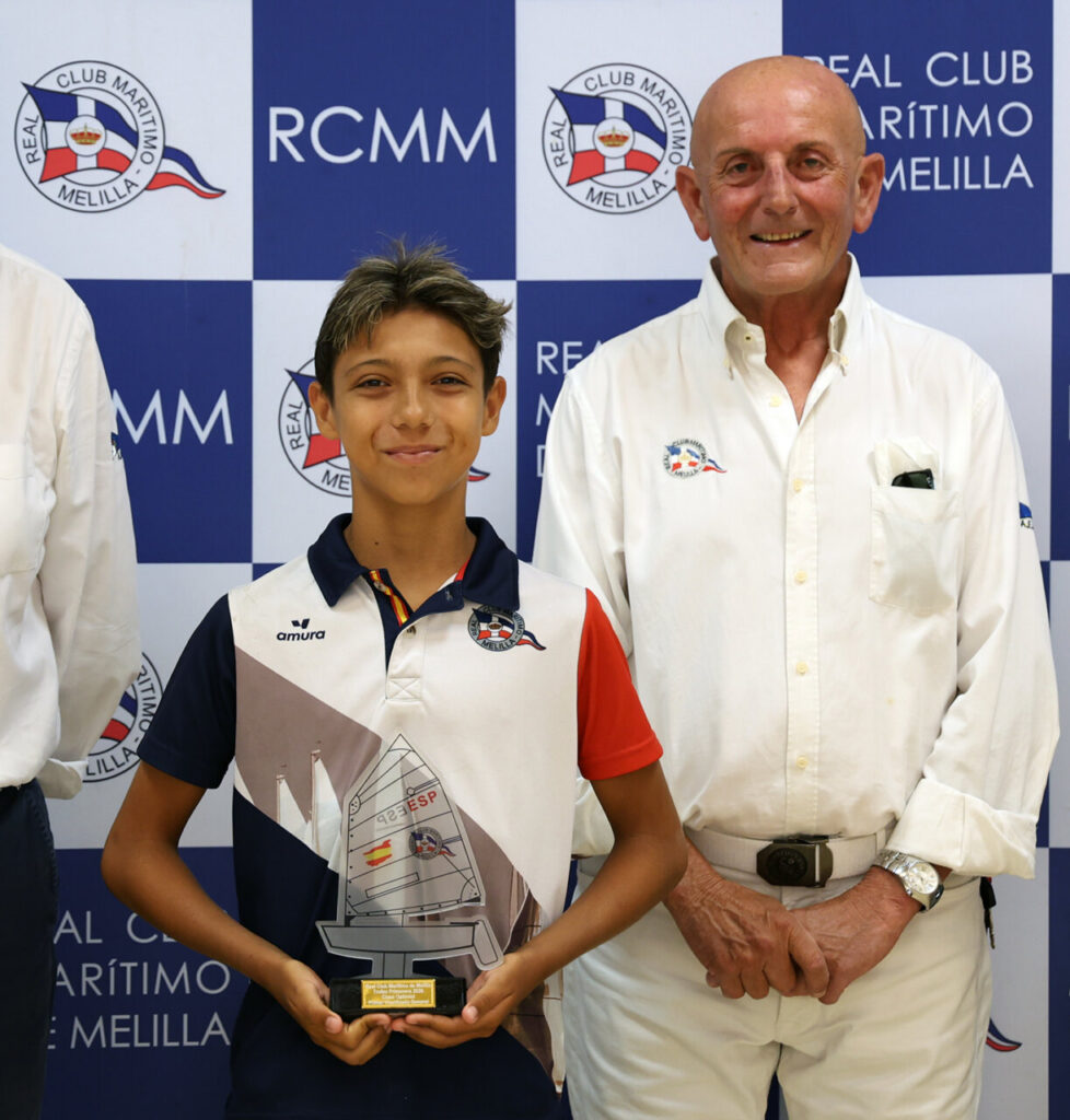 Joven ganador sosteniendo trofeo en el Real Club Marítimo de Melilla