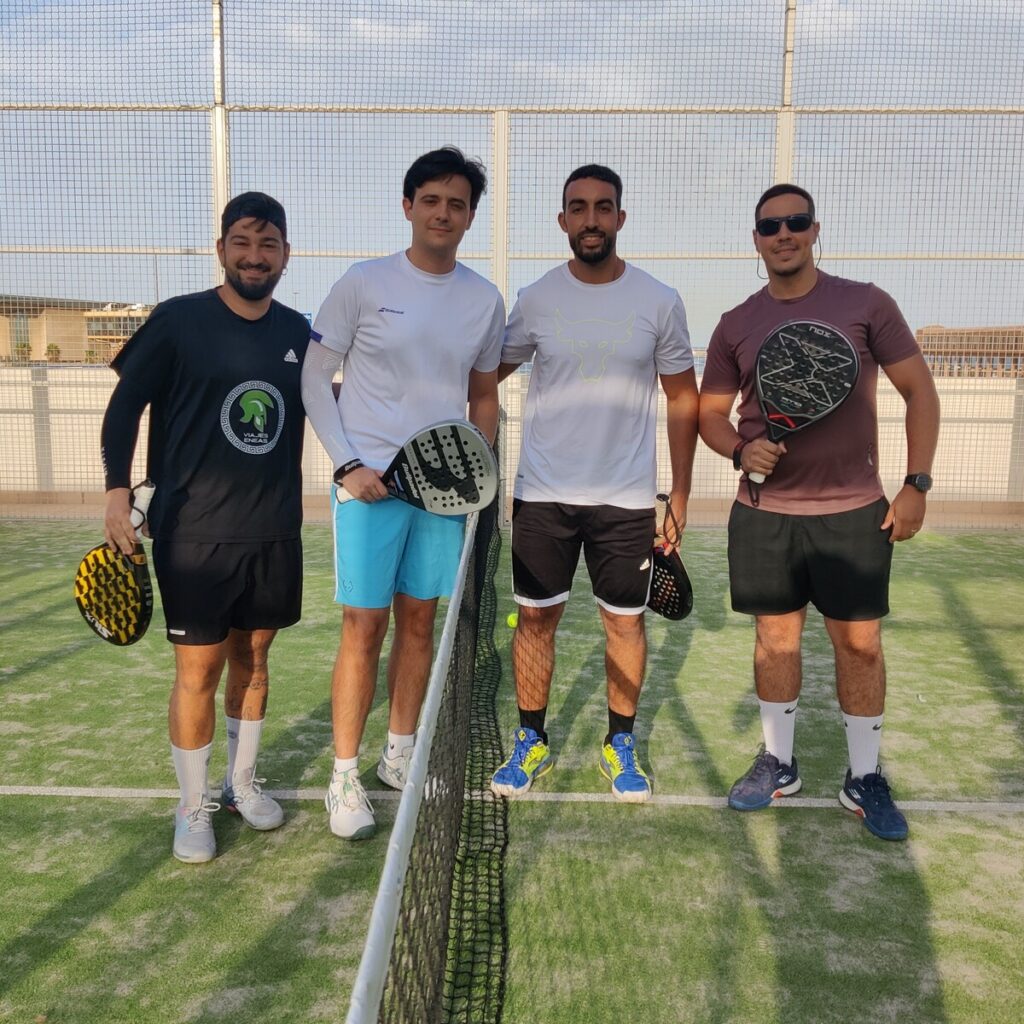 Cuatro jugadores de pádel posando en la cancha