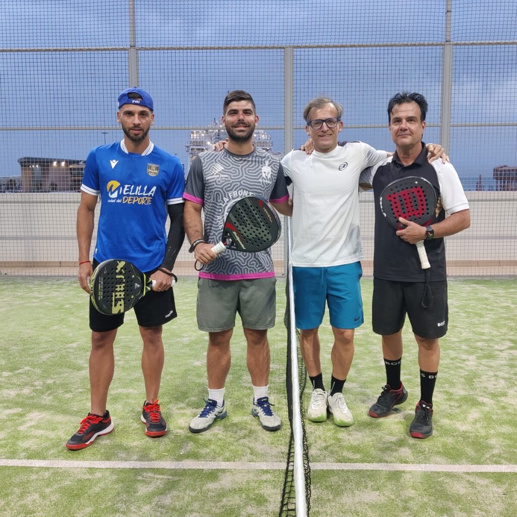 Cuatro jugadores de pádel posando en la cancha tras el torneo
