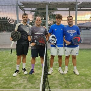Cuatro jugadores de pádel posando en la cancha tras el torneo