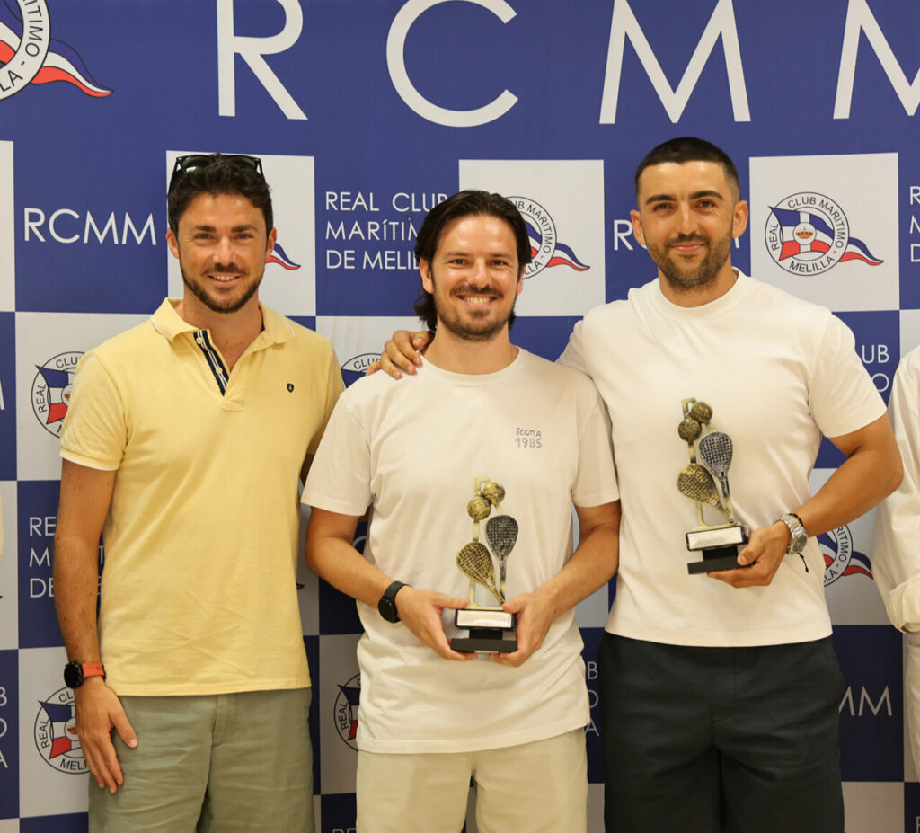 Three men pose with trophies at an awards event in front of a blue RCMM backdrop.