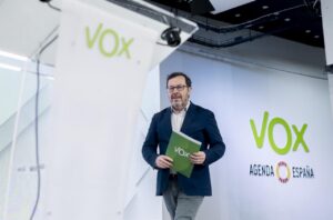 Un representante de Vox sostiene un documento en un evento político