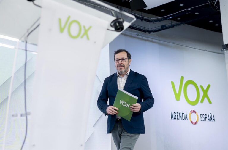 Un representante de Vox sostiene un documento en un evento político
