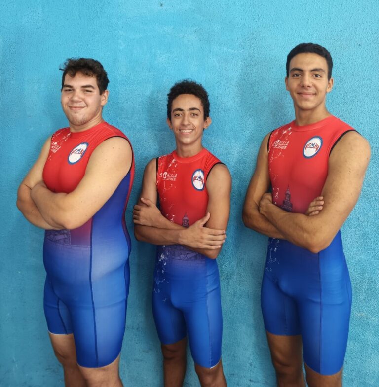 Tres jóvenes atletas de halterofilia posando en trajes de competición