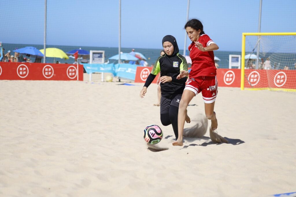 Jugadoras de fútbol playa compiten en la arena durante un partido