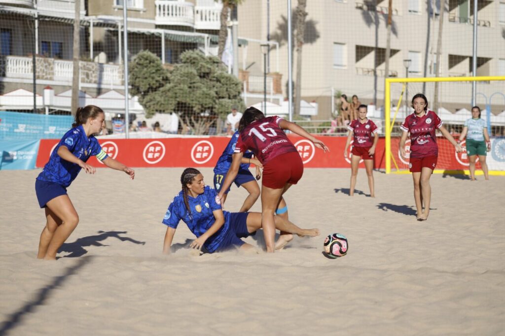 Jugadoras de fútbol playa compitiendo en la arena durante un partido