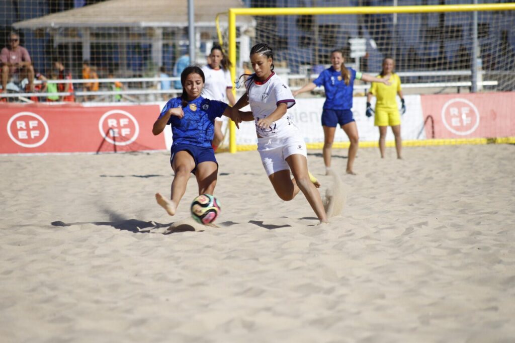 Jugadoras compitiendo en un partido de fútbol playa en la arena