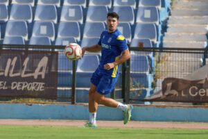 Jugador de la U.D. Melilla entrenando con un balón en el campo
