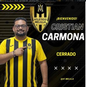 Cristian Carmona, entrenador del Atlético Melilla, sonriente con camiseta amarilla y negra.