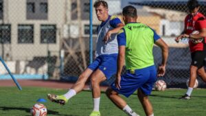 Ayoub Al Azami entrenando con su equipo de fútbol en el campo.