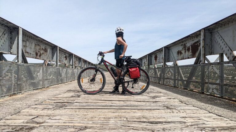 Ciclista en un puente de madera en un camino natural