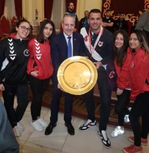 Miembros del Club Balonmano Base Melilla sosteniendo un trofeo
