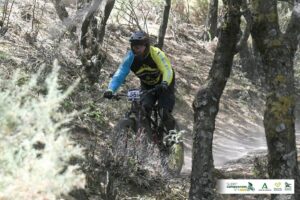 Ciclista compitiendo en un sendero de montaña durante una carrera de enduro