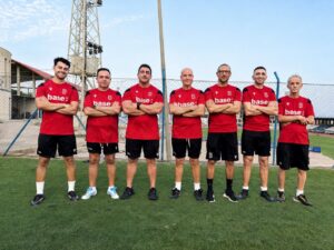 Cuerpo técnico de la U.D. Melilla posando en el campo de fútbol