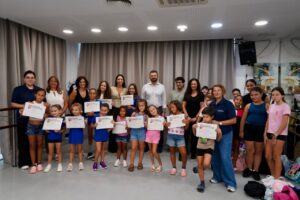 Grupo de niños y adultos sosteniendo diplomas en un evento de Educa Verano