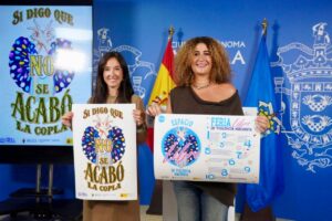 Dos mujeres sosteniendo carteles sobre la feria libre de violencias machistas