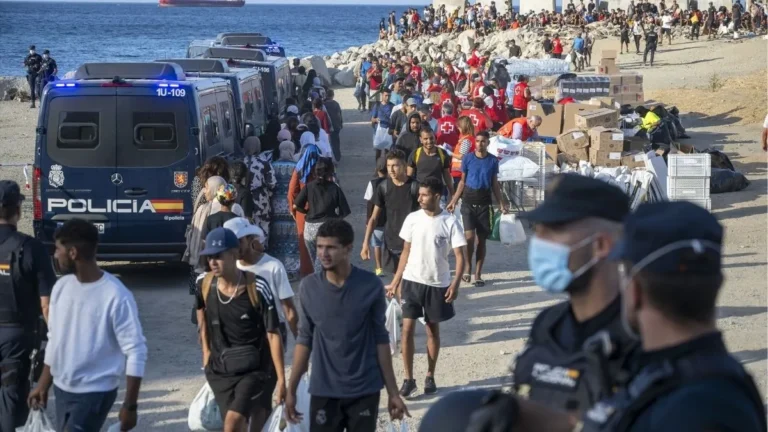 Grupo de inmigrantes en Ceuta siendo atendidos por médicos y servicios de emergencia