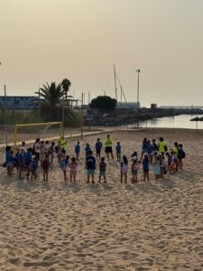 Niños participando en actividades en la playa durante las Colonias de Verano 2026.
