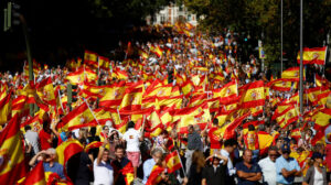 Multitud de personas ondeando banderas españolas en una manifestación