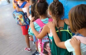 Grupo de niños en fila con mochilas escolares en Melilla