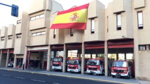 Parque de bomberos en Melilla con camiones de bomberos y bandera española