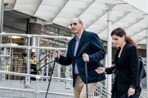 Juan Carlos Peinado y una mujer saliendo de un edificio judicial