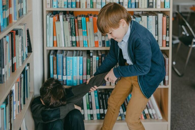 Niños en una biblioteca, uno parece estar acosando al otro.