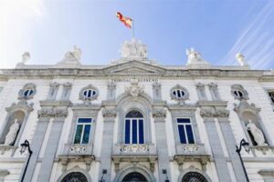 Facade of the Supreme Court building, a white neoclassical structure with statues, arched windows, and a Spanish flag on top.