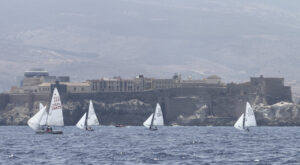 Regatas de vela ligera en Melilla con barcos y paisaje urbano