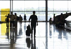 Pasajeros en un aeropuerto con maletas y controles de seguridad