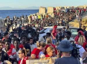 Multitud de migrantes en la costa de Ceuta con voluntarios de ayuda