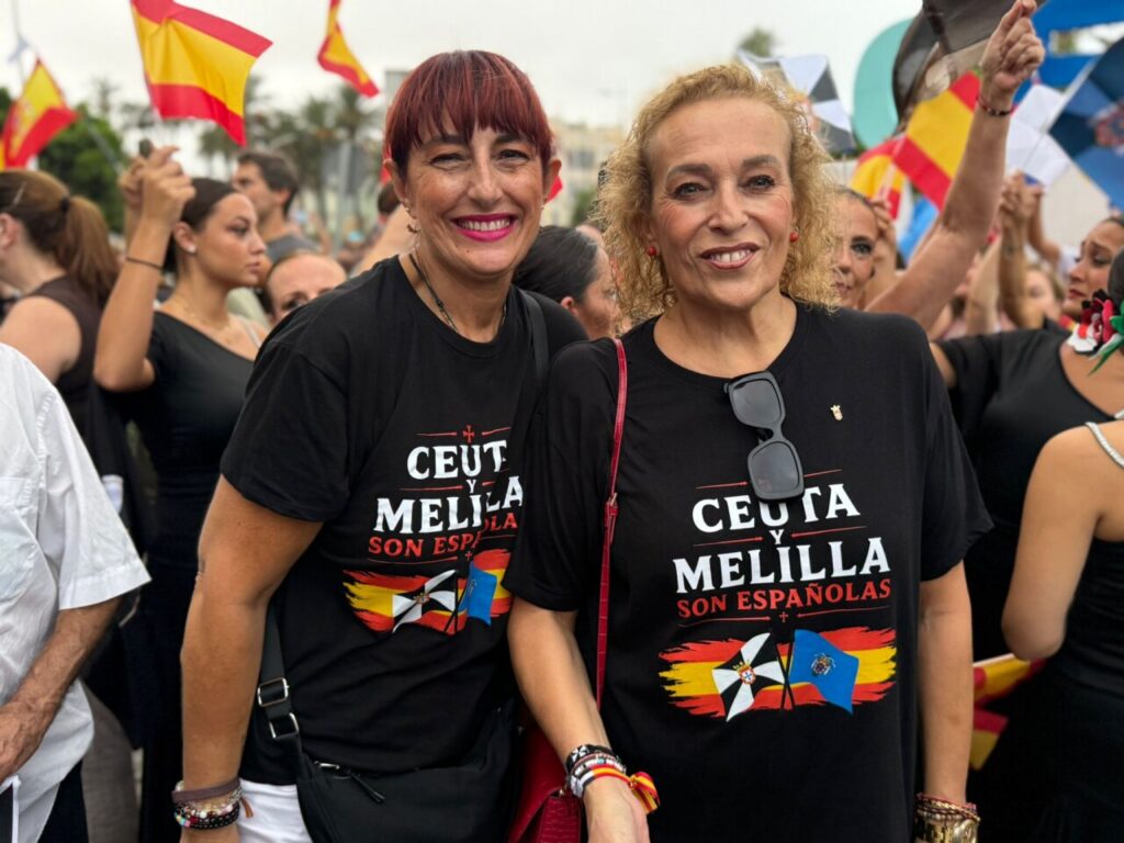 Dos mujeres sonrientes con camisetas en apoyo a Ceuta y Melilla en una concentración