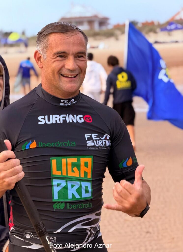 Competidor de surf sonriente en la playa durante el campeonato