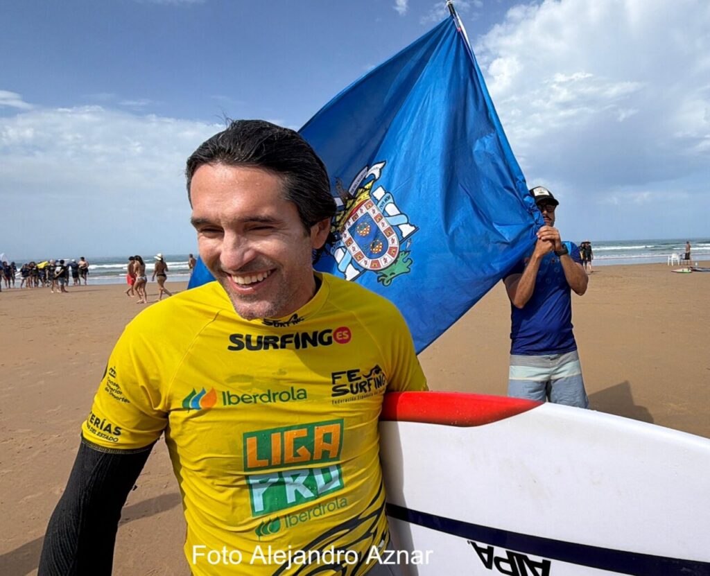 Competidor sonriente en el Campeonato de España de Surf con bandera
